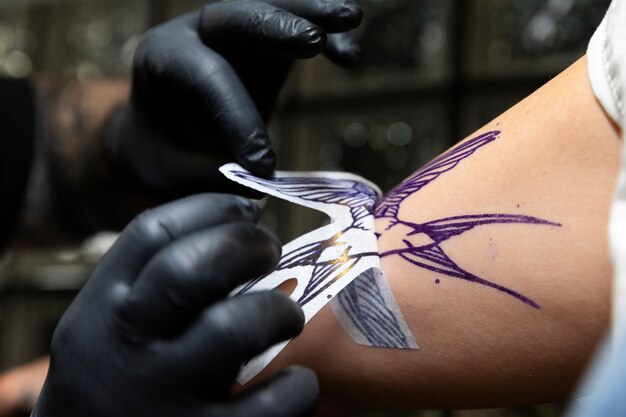 Contorno de tatuagem sendo transferido para a pele